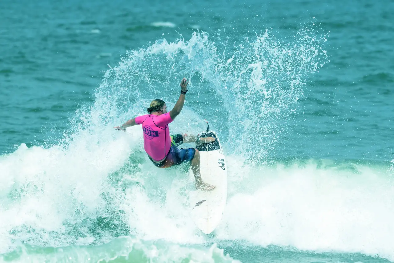 A competitive surfer performing a turn on a wave