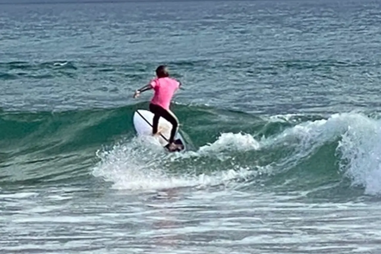 A parent and child learning to surf together