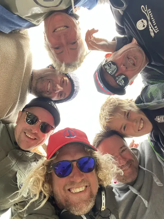 The Pro Surf Coaching team photographed from below, gathered in a circle