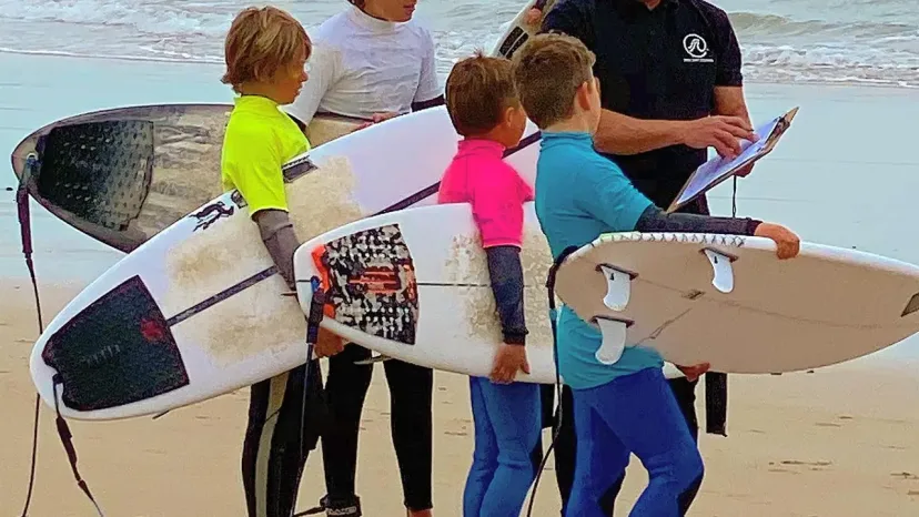 Young grommets carrying boards down the beach at a Pro Surf Coaching lesson