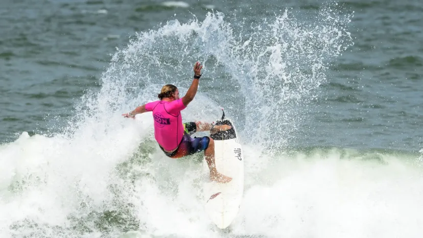A competitive surfer performing a turn on a wave