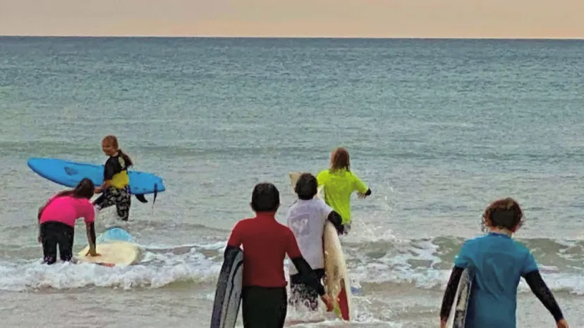A Pro Surf Coaching coach in the surf with a student
