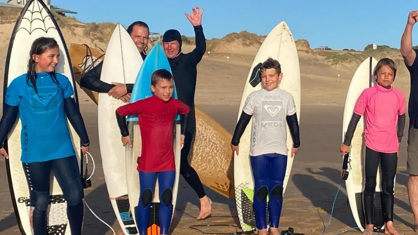 A parent and child surfing together at Smiths Beach
